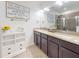 Bathroom featuring a double vanity with dark cabinets and a framed quote on the wall at 8635 Tallfield Ave, Orlando, FL 32832