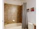 Bathroom tiled shower/tub with shower curtain and decorative photos on wall at 8635 Tallfield Ave, Orlando, FL 32832