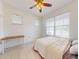 Bedroom featuring a ceiling fan, white walls and floors, desk, and large window overlooking yard at 8635 Tallfield Ave, Orlando, FL 32832