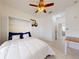 Bright bedroom with white walls, ceiling fan, and murphy bed with blue pillows and white bedding at 8635 Tallfield Ave, Orlando, FL 32832
