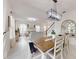 Bright dining area features an elegant light fixture, a wooden dining table and complements the cozy living room at 8635 Tallfield Ave, Orlando, FL 32832