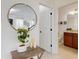 Close up of Foyer with wood look floors, round decorative mirror, and view to bathroom at 8635 Tallfield Ave, Orlando, FL 32832