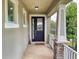 View of front porch with stone pillar accents, decorative wreath on front door, and black hardware at 8635 Tallfield Ave, Orlando, FL 32832