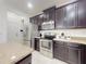 Modern kitchen features stainless steel appliances, dark wood cabinets, a stone countertop island, and bright lighting at 8635 Tallfield Ave, Orlando, FL 32832