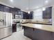 Modern kitchen with stainless steel appliances, granite countertops, island, and stylish dark wood cabinetry at 8635 Tallfield Ave, Orlando, FL 32832