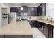 Spacious kitchen features stainless steel appliances, large center island and dark cabinetry at 8635 Tallfield Ave, Orlando, FL 32832