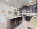 Kitchen featuring stainless steel appliances, center island with countertop, and modern dark cabinetry at 8635 Tallfield Ave, Orlando, FL 32832