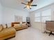 Cozy living room with a comfortable sofa, ceiling fan, and plenty of natural light for relaxed living at 8635 Tallfield Ave, Orlando, FL 32832