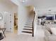 Open floor plan with stairway and bathroom off the entry, flowing into kitchen and living areas at 8635 Tallfield Ave, Orlando, FL 32832