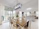 Bright open-concept design seamlessly connects dining and living areas with white plank flooring and lots of natural light at 8635 Tallfield Ave, Orlando, FL 32832