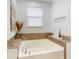 Relaxing main bathroom with a soaking tub, decorative accents, and ample natural light at 8635 Tallfield Ave, Orlando, FL 32832