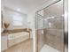 Bathroom featuring a separate soaking tub, glass shower enclosure, and tile flooring at 8635 Tallfield Ave, Orlando, FL 32832