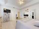 Spacious main bedroom features a tray ceiling, a large TV and en suite bathroom at 8635 Tallfield Ave, Orlando, FL 32832