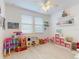 Bright playroom with large windows, a ceiling fan, hard surface floors, and plenty of shelving at 8635 Tallfield Ave, Orlando, FL 32832