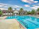 Community pool with sun loungers, palm trees, and a clubhouse, perfect for relaxation and recreation at 8635 Tallfield Ave, Orlando, FL 32832