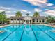 A community pool featuring palm trees, lounge chairs, and a clubhouse at 8635 Tallfield Ave, Orlando, FL 32832