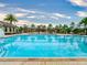 Bright and inviting community pool featuring lounge chairs, palm trees, and clear blue water at 8635 Tallfield Ave, Orlando, FL 32832