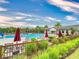 Community pool with lounge chairs and umbrellas, surrounded by lush landscaping and a decorative fence at 8635 Tallfield Ave, Orlando, FL 32832