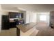 Bright kitchen featuring dark appliances, tiled floors, and a breakfast bar overlooking the carpeted living area at 1895 Hickory Bluff Rd, Kissimmee, FL 34744