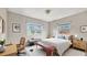 Staged bedroom featuring neutral decor, two windows, and a comfortable bed with stylish accents at 1013 Carefree Cove Dr, Winter Haven, FL 33881