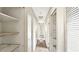 Long hallway with multiple doorways and shelving, offering convenient access to different areas of the house at 1013 Carefree Cove Dr, Winter Haven, FL 33881