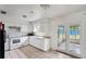 Bright kitchen featuring white cabinetry, appliances, and a door leading to the backyard at 1013 Carefree Cove Dr, Winter Haven, FL 33881