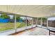 Patio with damaged screening and view of an overgrown backyard at 1013 Carefree Cove Dr, Winter Haven, FL 33881