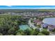 Aerial view of a community with pickleball court and lush trees surrounding homes near a lake at 10734 Dawson Lily Way # S, Orlando, FL 32832
