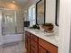 Well-lit bathroom featuring a double vanity with modern fixtures and a shower with glass doors at 10734 Dawson Lily Way # S, Orlando, FL 32832