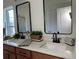 Elegant bathroom featuring a double vanity, framed mirrors, and modern fixtures at 10734 Dawson Lily Way # S, Orlando, FL 32832