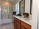 Bright bathroom featuring a double vanity, framed mirrors, and glass-enclosed shower at 10734 Dawson Lily Way # S, Orlando, FL 32832