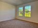 Bright bedroom featuring neutral carpet, light colored walls, and two large windows at 10734 Dawson Lily Way # S, Orlando, FL 32832