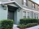 Charming townhome exterior with a covered entry, green paint, and well-maintained landscaping at 10734 Dawson Lily Way # S, Orlando, FL 32832