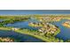 Aerial view showcasing waterfront homes nestled along canals and lakes, surrounded by lush landscaping and blue skies at 1110 Terralago Way, Kissimmee, FL 34746