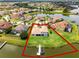 Aerial view of a waterfront home with private dock access, surrounded by a lush green lawn and mature trees at 1110 Terralago Way, Kissimmee, FL 34746