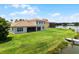 Home rear, featuring a screened porch, green lawn, and access to the canal at 1110 Terralago Way, Kissimmee, FL 34746