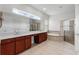 Bright bathroom featuring dual sinks, a soaking tub, glass enclosed shower, window and a large mirror at 1110 Terralago Way, Kissimmee, FL 34746