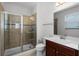 Bathroom featuring tiled shower, wood vanity, and large framed mirror at 1110 Terralago Way, Kissimmee, FL 34746