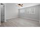 Bright bedroom featuring wood-look floors, ceiling fan, and natural light from two windows at 1110 Terralago Way, Kissimmee, FL 34746