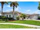 Beautiful home featuring mature palm trees, manicured lawn, arched windows, and a brick driveway at 1110 Terralago Way, Kissimmee, FL 34746