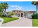 Beautiful home featuring a three-car garage, well-manicured lawn, and large palm trees at 1110 Terralago Way, Kissimmee, FL 34746