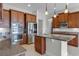 Kitchen area featuring granite countertops, stainless steel appliances, wood cabinets, and tile flooring at 1110 Terralago Way, Kissimmee, FL 34746