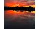 Scenic lake view reflecting vibrant orange and red colors from the sunset sky and neighborhood homes at 1110 Terralago Way, Kissimmee, FL 34746