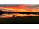 Scenic lake view at sunset with vibrant orange and red reflections on the water and clear visibility of neighborhood homes at 1110 Terralago Way, Kissimmee, FL 34746
