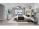 Bright main bedroom featuring tray ceilings, tile floors, fan, TV, sitting area, and waterfront views at 1110 Terralago Way, Kissimmee, FL 34746