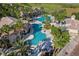 Aerial view of a community pool area with palm trees, lounge chairs, a slide, and well-maintained landscaping at 1110 Terralago Way, Kissimmee, FL 34746