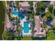 Bird's eye view of a community pool featuring palm trees, lounge chairs, and meticulously maintained landscaping at 1110 Terralago Way, Kissimmee, FL 34746