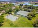 Aerial view of community tennis and basketball courts surrounded by green spaces, lush landscaping, and nearby homes at 1110 Terralago Way, Kissimmee, FL 34746
