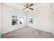 Bright bedroom with neutral carpet, ceiling fan, and three windows providing ample natural light and neighborhood views at 121 Longview Ave, Celebration, FL 34747