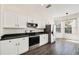Kitchen with stainless steel appliances, white cabinets, and a bright bay window overlooking the backyard at 121 Longview Ave, Celebration, FL 34747